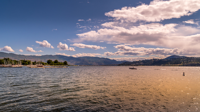 An image on the Cascadia Pacific Realty website, a Kelowna real estate agent. The image showcases a stunning view of Kelowna from the water